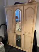 A triple wardrobe with mirrored central door.