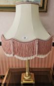 A single side lamp raised over a heavy brass column, with fringed shade, 80cm high.