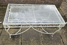 A cream painted metal garden table with glass top, 100 x 55 x 50cm.