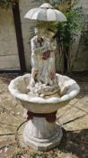 A decorative stoneware fountain - young couple with umbrella over fluted base, 140cm high