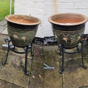 A pair of glazed platers each raised over iron base, 39cm dia, 66cm high.