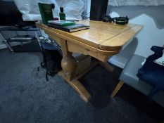 An oak pull out dining table raised over spherical supports.