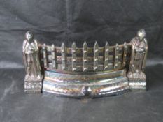 A cast iron fire grate having knight theme.