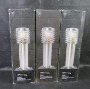 Three brushed stainless steel bollard garden path or driveway lights.