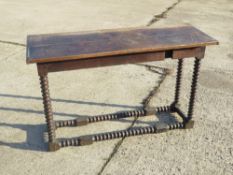 An antique oak console or hall table having barley twist legs and stretchers.