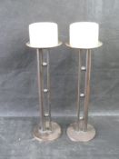 A pair of contemporary candlesticks with candles.