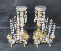 A pair of brass candlestick with later applied plastic drops, together with another similar.