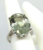 A silver cocktail ring having large oval cut solitaire in pale green, size K/L.