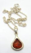 A silver and amber pendant on silver chain.