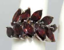 A silver and garnet floral spray design ring, size J/K.