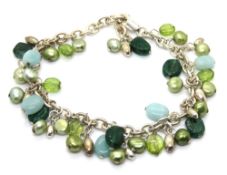 A silver 'charm bracelet' profusely decorated with blue and green glass and pearl beads.