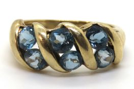 A 9ct gold and topaz ring, three pairs of round cut topaz set in ribbon of gold hallmarked 375,