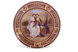 A 19th Century Vienna porcelain plate, the centre painted with two classical figures with beehive