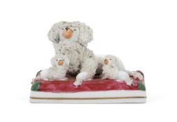 19th Century Staffordshire Poodle and Pups seated on a rectangular cushion base 9cm long 9cm long