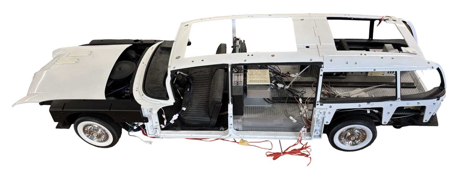 A Ghost Busters Ecto-1 building kit, partially built with some components and magazines in