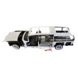 A Ghost Busters Ecto-1 building kit, partially built with some components and magazines in