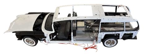 A Ghost Busters Ecto-1 building kit, partially built with some components and magazines in