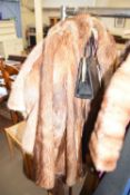 A lady's fur jacket and a leather handbag
