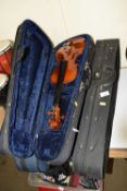 Two cased modern violins