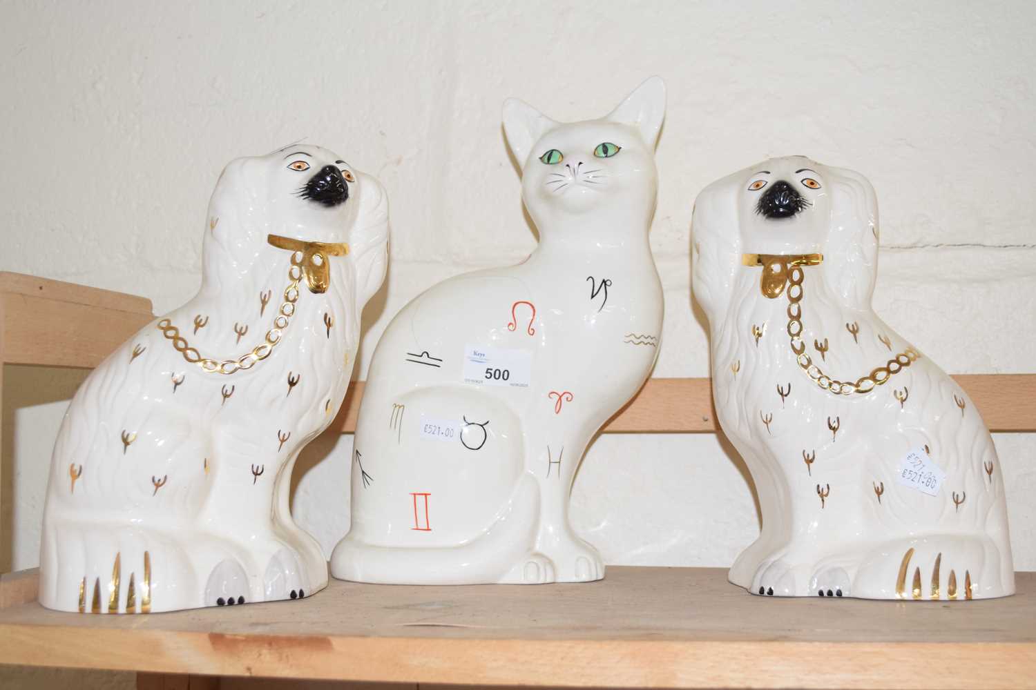 A pair of Staffordshire style dogs together with a cat