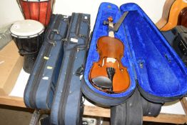 Three cased modern violins