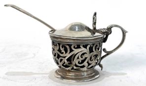 A Victorian silver mustard pot and liner having a pierced scroll decorated body, a double scroll