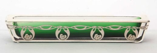 An Art Nouveau green glass and white metal overlaid pen trough of elongated form, decorated to one