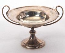 An Edwardian silver small twin handled tazza formed dish of plain form on a spreading pedestal foot,