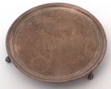 A George III silver waiter of plain circular form having a slight raised beaded rim and supported on