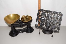 A pair of cast iron and brass weight kitchen scales together with a cast iron book stand