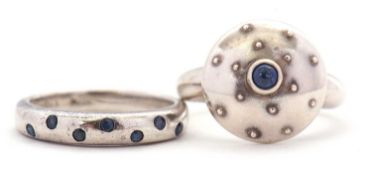 Two silver and sapphire rings: one with domed studded centre section with single round sapphire