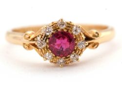 An 18ct Edwardian ruby and diamond ring, the central round ruby surrounded by single cut diamonds