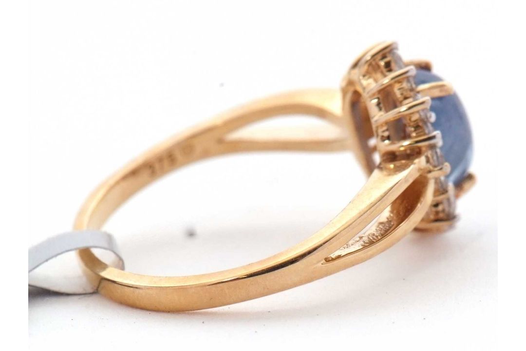 A 9ct sapphire and white zircon ring, the central oval sapphire cabochone, surrounded by small round - Image 2 of 6