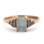 A 9ct aquamarine ring, set with an emerald cut aquamarine and three small round aquamarines to