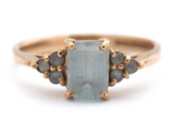 A 9ct aquamarine ring, set with an emerald cut aquamarine and three small round aquamarines to