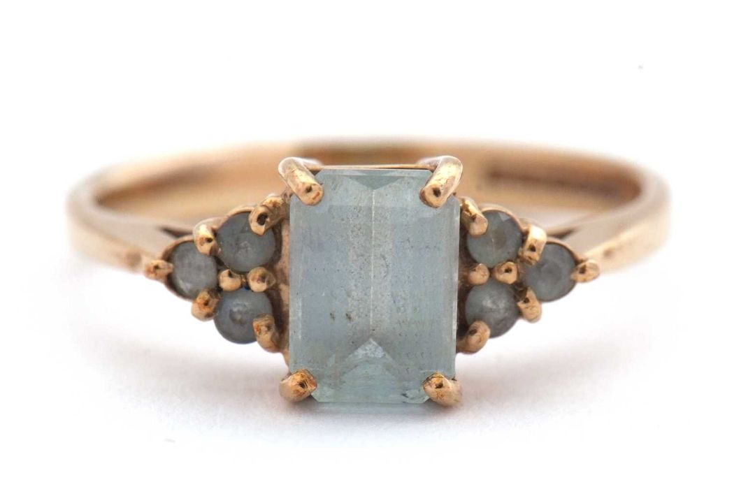 A 9ct aquamarine ring, set with an emerald cut aquamarine and three small round aquamarines to - Image 1 of 8