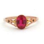 A synthetic ruby ring, the oval synthetic ruby with tapered shoulders and plain band stamped 9ct,