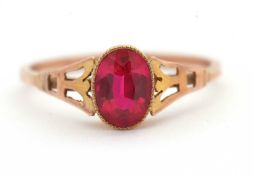 A synthetic ruby ring, the oval synthetic ruby with tapered shoulders and plain band stamped 9ct,