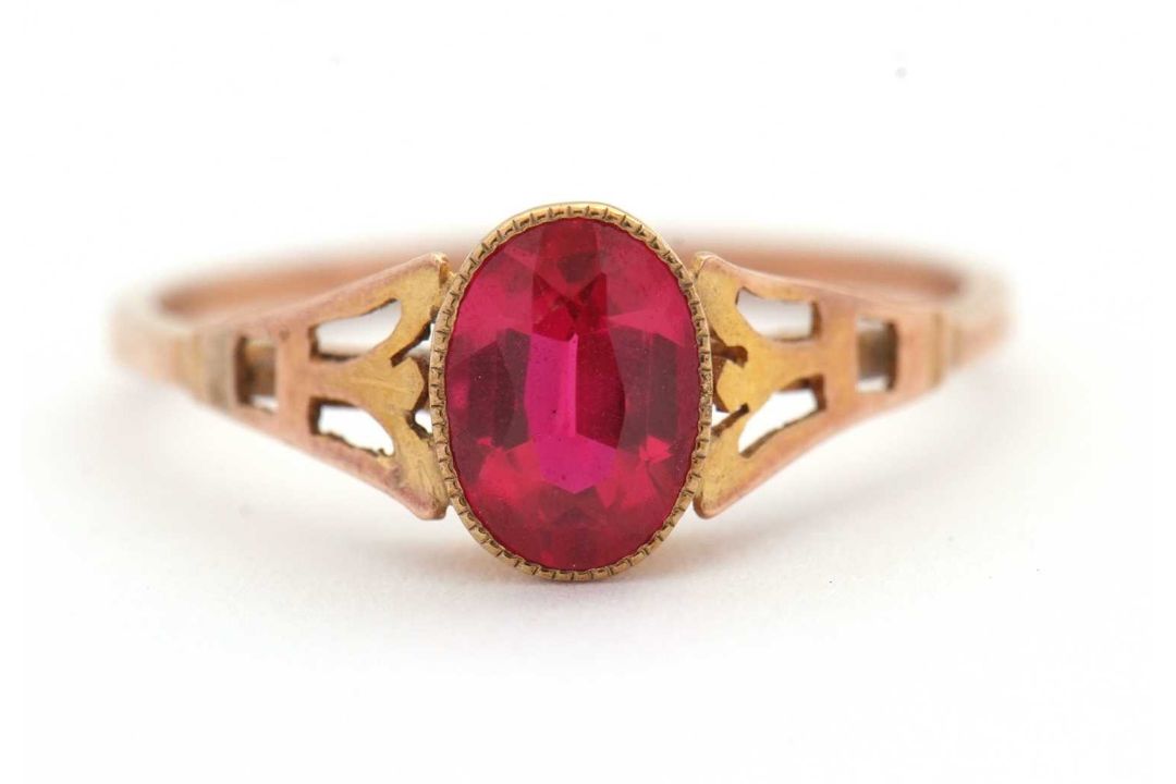 A synthetic ruby ring, the oval synthetic ruby with tapered shoulders and plain band stamped 9ct, - Image 1 of 8