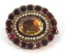 A 19th century gemset brooch, the central foil backed oval citrine surrounded by seed pearls, with