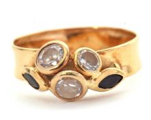 A custom made gemset ring, set with two blue-black marquise sapphires and three white stones, all in