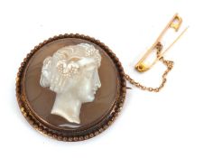 A hardstone cameo brooch, the round hardstone cameo of a lady with vines in her hair, in unmarked