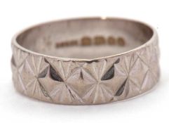 An 18ct ring, 6mm wide, with impressed decoration, hallmarked London 1970, size K-L, 3.0g