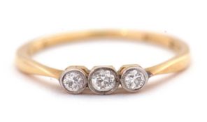 A three stone diamond ring, the three old European cut diamonds in millegrain mounts, with plain