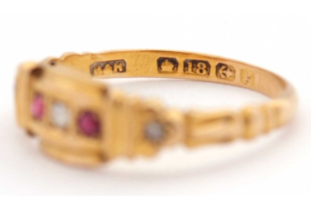 An Edwardian 18ct ruby and diamond ring, set with a central round diamond and a round ruby to either - Image 2 of 7