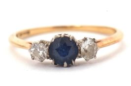A sapphire and diamond ring, the central round sapphire set to either side with an old mine cut