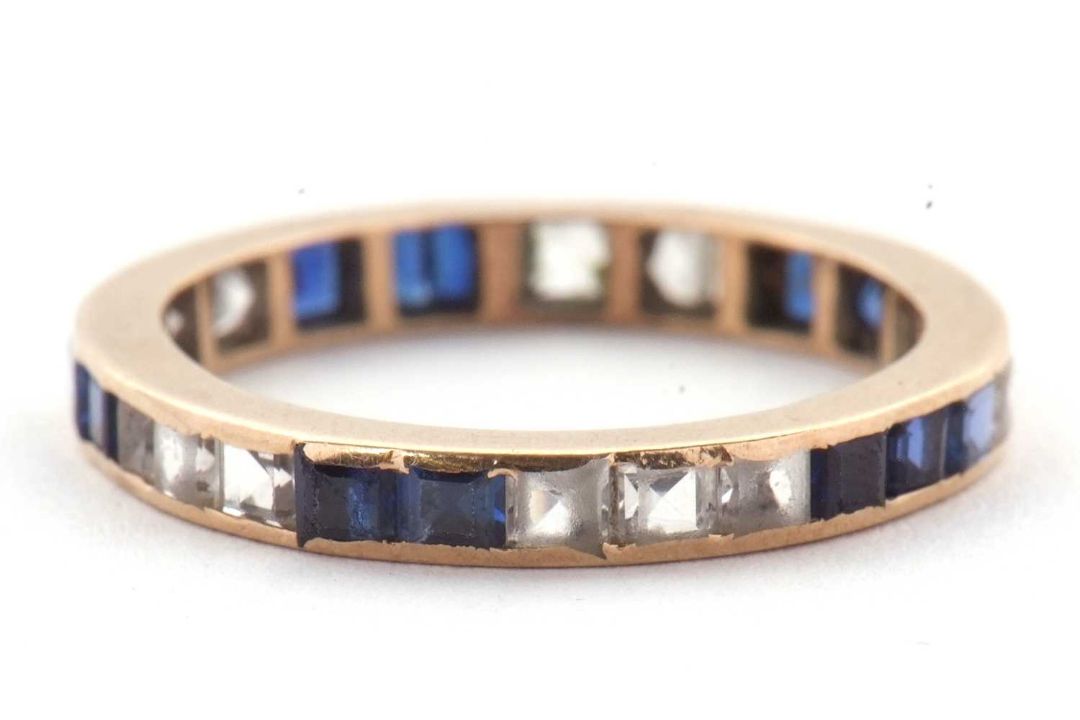 A blue and white stone eternity ring, the full hoop ring with channel set with blue and white - Image 1 of 3