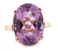 An amethyst ring, the oval mixed cut amethyst in a four claw mount, with plain band stamped 9ct,