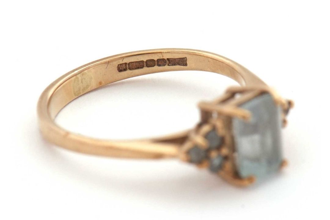 A 9ct aquamarine ring, set with an emerald cut aquamarine and three small round aquamarines to - Image 7 of 8