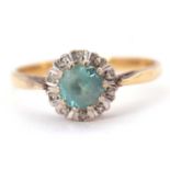 An 18ct blue zircon and diamond ring, the central round blue zircon surrounded by illusion set